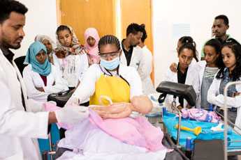 Clinicians demonstrate post-natal procedure.