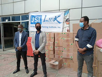 Men wearing masks stand in front of L10K supplies.